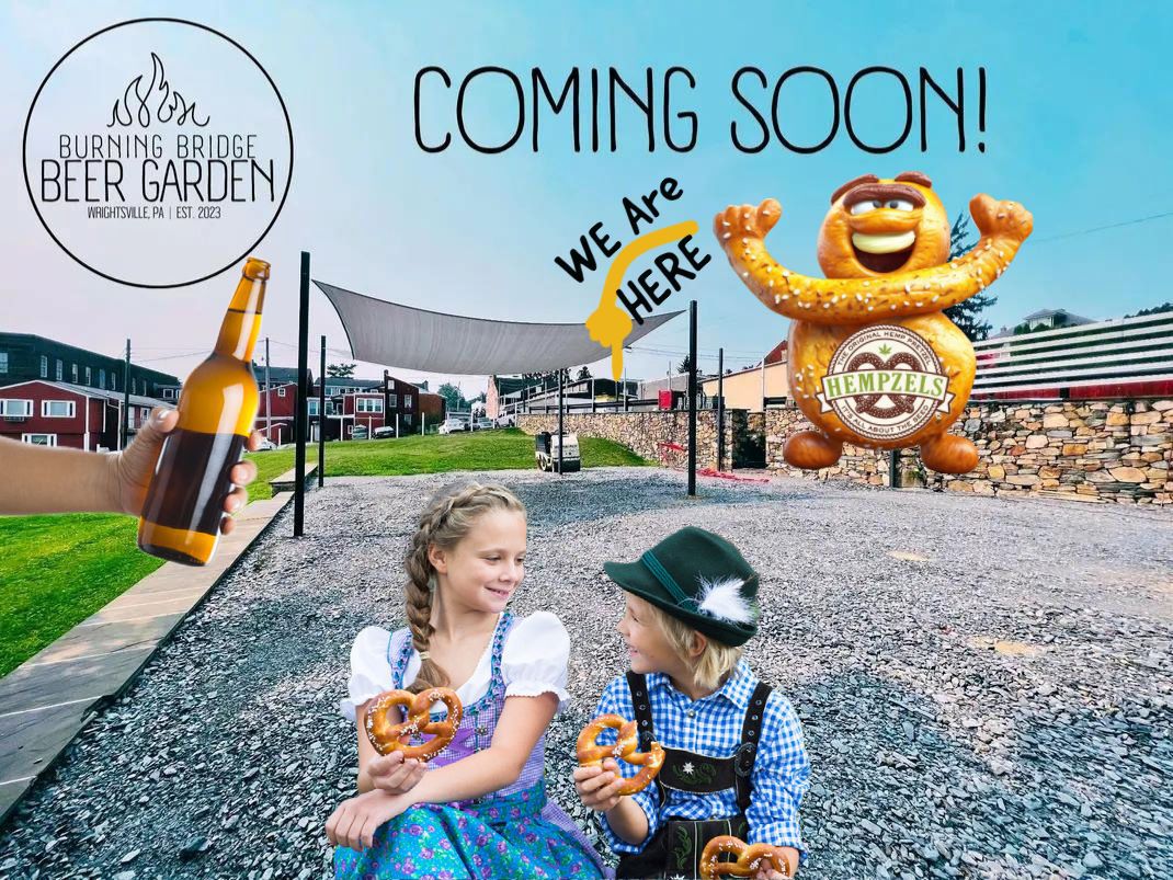 children in bavarian outfits eating pretzels in front of empty beer garden & hempzels mascot