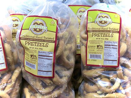 Hempzel Pretzels in a clear 1lb bag with yellow, red, gold labeling with more bags around it.