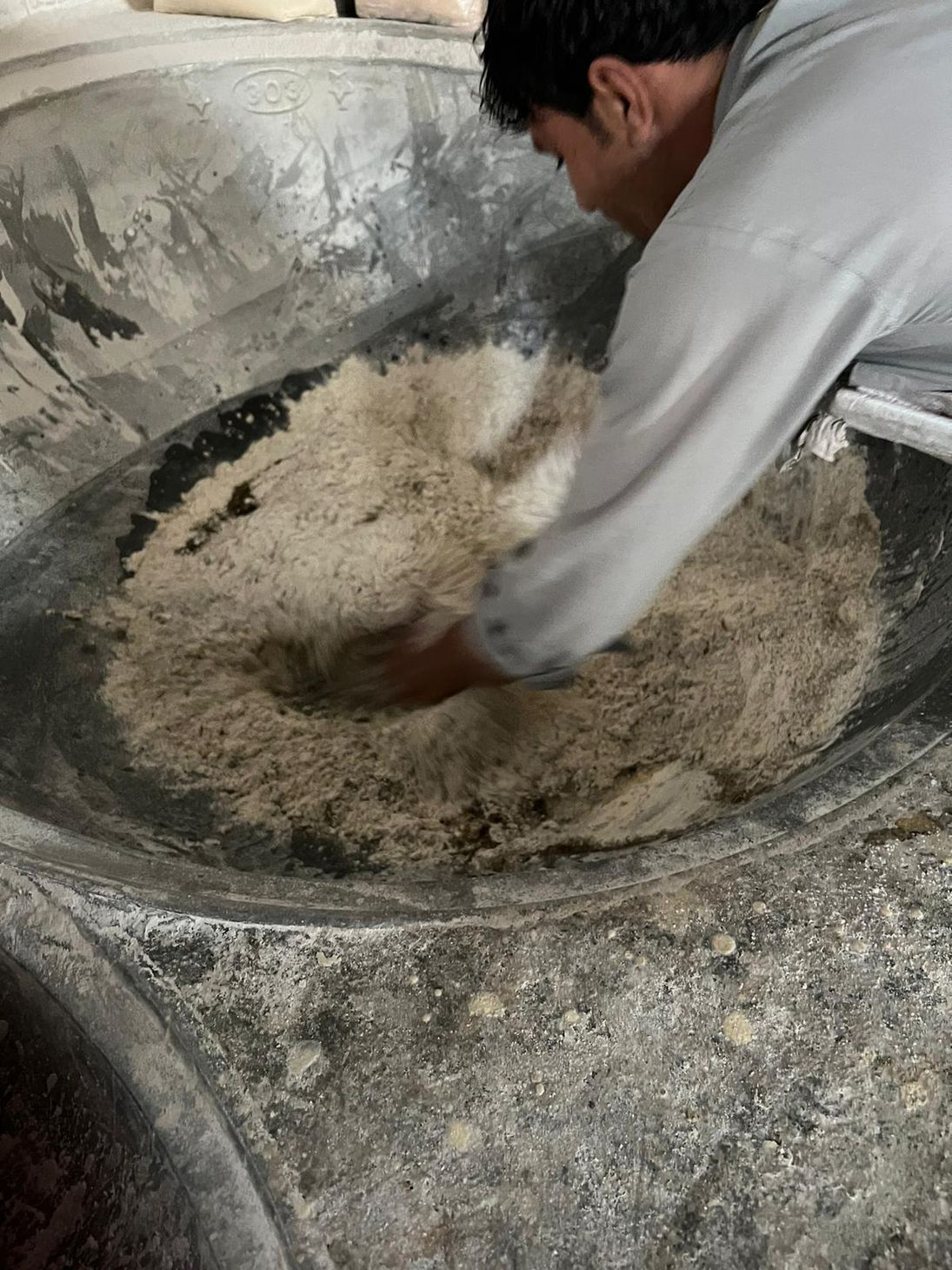 hand blending hemp flour in a giant bowl 