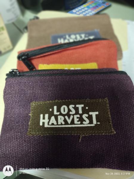 Purple Lost Harvest hemp Fabric Bags Lined Up with Red and brown bags stacked for display.