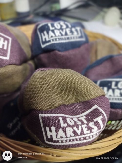 Brown, Purple, Fabric hackey sacks piled up with Lost Harvest Marked on hemp hacs.