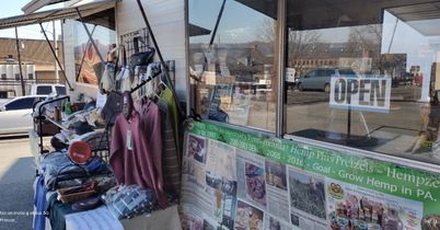 Image of open sign side of concession trailer with hemp shirts, hemp twine, hemp sodas.