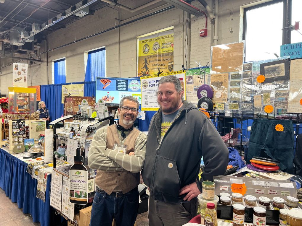 Owner Shawn House standing in front of booth at the PA Farm Show with the mayor of Modena PA