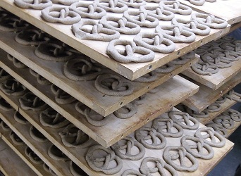 Trays of unbaked hand rolled sourdough hemp pretzels waiting to go into the pretzel oven.