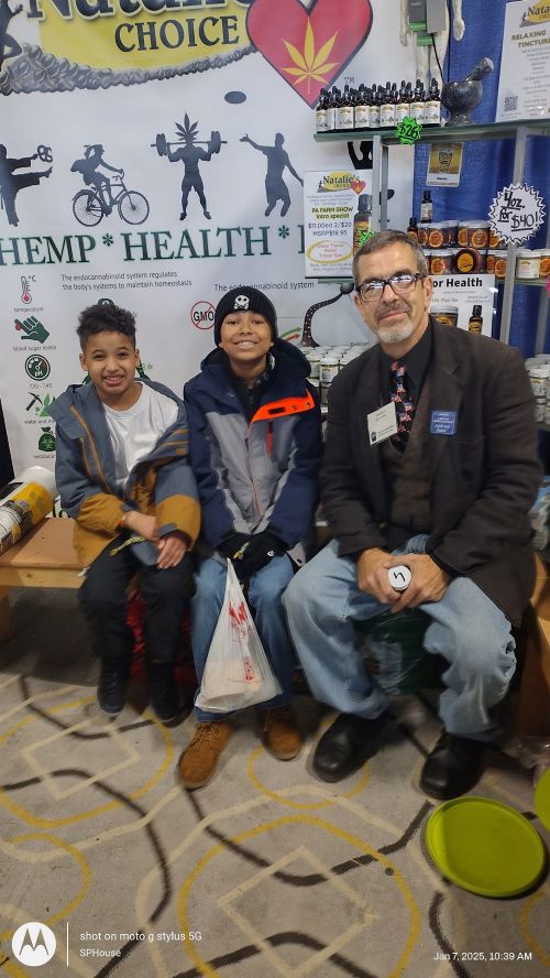 Owner Shawn House sits with two young boys after hearing the just say know tour about hemp.