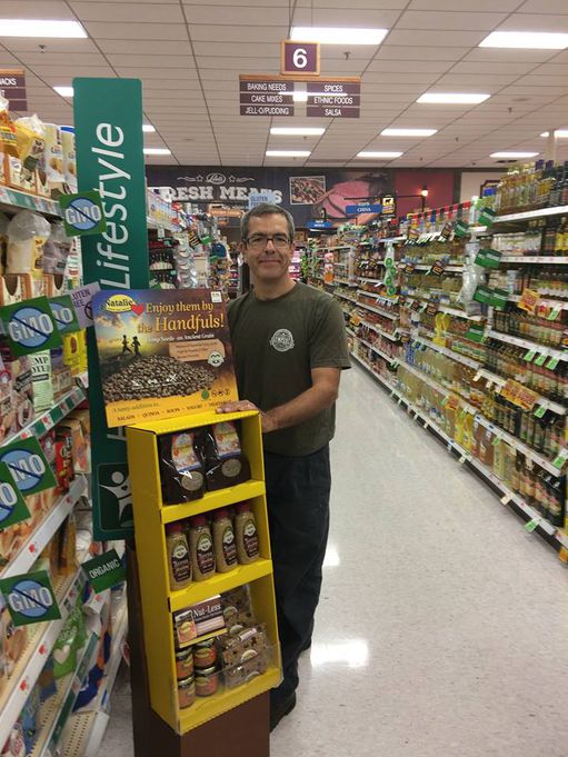 Owner Shawn House standing in a super market aisle photogrpahic image of display for mustard.