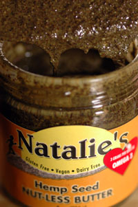 Open jar of brown green hemp seed butter or spread in a yellow NataliesChoice brown yellow label