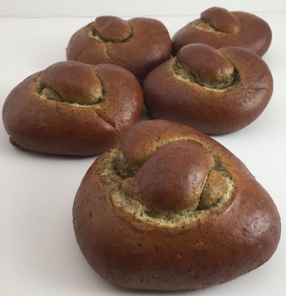 4 big soft pretzel rolls are lined up one after the other without salt nice and brown.