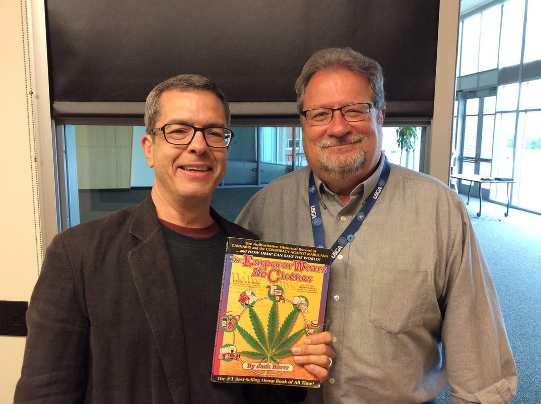 Shawn House holding a book The Emperor Wears No Clothes with Scott Lamar host of Smart Talk