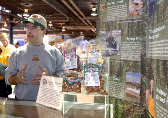 Owner Shawn House with 5 selections of Hemp pretzels with HIA hemp information posters