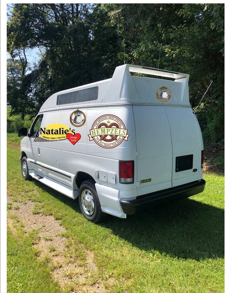 WHite High top van with back doors closed and logos of our company brands on the side.